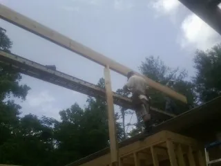 Carpenter setting a ridge beam over a new addition frame — Ice Dam Removal by Roofing Brothers in Spangle
